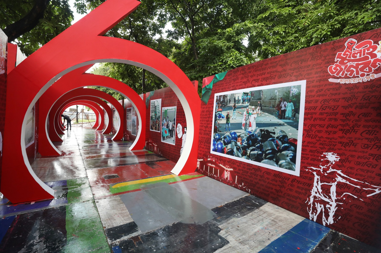 Volunteers apply the finishing touches to the 36-Point Photo gallery display, preparing for the ‘July Jagoron’ commemoration event in Dhaka. (Photo: A H Mintu/V7N)